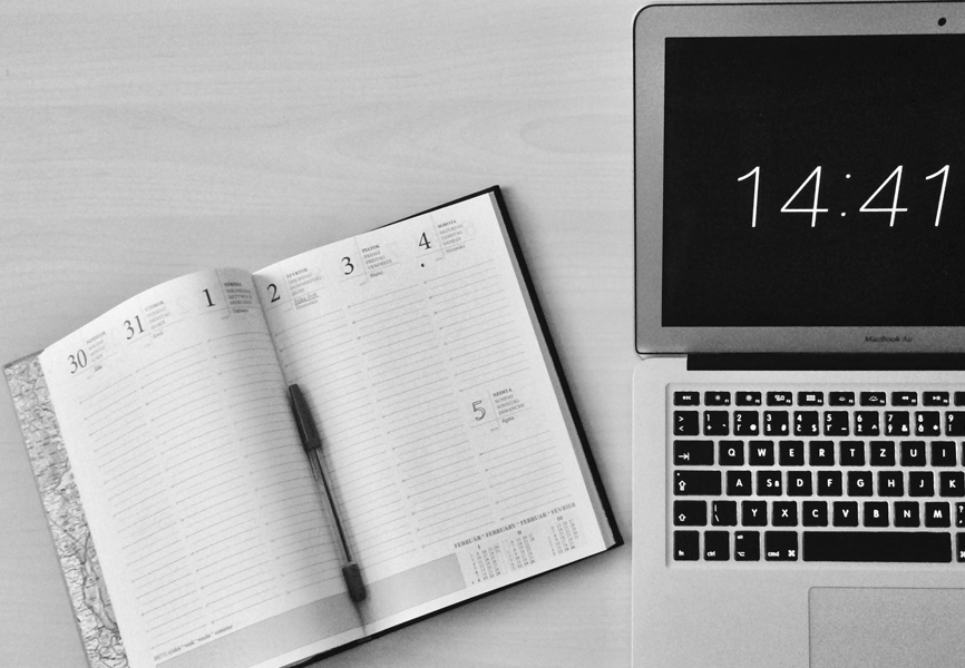 macbook and planner on work desk